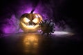 Halloween during Corona virus global pandemic concept. Glowing pumpkins and Covid novel on dark with thematic spooky decorations.