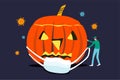 Halloween in COVID-19 Coronavirus pandemic concept, horror halloween pumpkin with healthcare staff try to wear face mask with