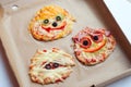 Halloween creative scary food monster zombie face with eyes pizza snack with mozzarella, basil and sausage in craft box. Royalty Free Stock Photo