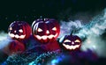 Halloween, cyber party, neon light. Three pumpkins on stones