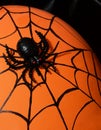 Halloween decor - black spider and cobwebs on a solid orange background