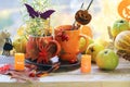 Halloween decor, a couple of cups with a drink, decorative candles, pumpkins, berries, leaves on the windowsill Royalty Free Stock Photo