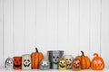 Halloween decor display of Jack o Lantern candle holders against a white wood background