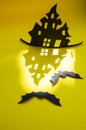 Halloween and decoration concept - bats, pumpkins, gloomy paper house, gloomy black tree branches on a yellow background. Royalty Free Stock Photo