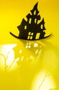 Halloween and decoration concept - bats, pumpkins, gloomy paper house, gloomy black tree branches on a yellow background. Royalty Free Stock Photo