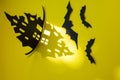 Halloween and decoration concept - bats, pumpkins, gloomy paper house, gloomy black tree branches on a yellow background. Royalty Free Stock Photo