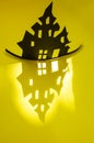 Halloween and decoration concept - bats, pumpkins, gloomy paper house, gloomy black tree branches on a yellow background. Royalty Free Stock Photo