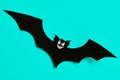 Halloween decoration concept. Scary black paper bat flying over blue background. Halloween.
