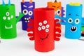 Halloween decoration. DIY and kids creativity concept. Monsters from toilet rolls and colored paper on a white table Royalty Free Stock Photo