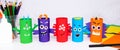 Halloween decoration. DIY and kids creativity concept. Monsters from toilet rolls and colored paper on a white table Royalty Free Stock Photo