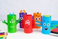 Halloween decoration. DIY and kids creativity concept. Monsters from toilet rolls and colored paper on a white table Royalty Free Stock Photo