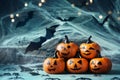 Halloween decoration with funny pumpkin heads, spider, web and flying bat on mystical bokeh background.