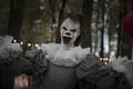 Halloween decoration, grinning clown standing on ghosts background