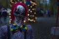 Halloween decoration, grinning clown standing on ghosts background