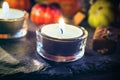 Halloween Decoration With Two Candlelights, Chocolate And Pumpkins On Slate