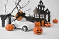 Halloween decorations. Close up retro toy car with pumpkins, gifts over tree branches. Horror and funny concept. Royalty Free Stock Photo