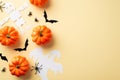 Halloween decorations concept. Top view photo of pumpkins spiders ghost skeleton and bats silhouettes on isolated beige background
