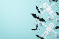 Halloween decorations concept. Top view photo of skeleton bat silhouettes spooky eyeballs and confetti on isolated light blue