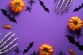 Halloween decorations on purple background. Happy Halloween concept. Flat lay pumpkins, bony hands, bats silhouettes, spiders