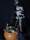 Halloween decorations, witch with her witches brew and her stick to stir