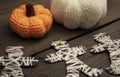 Halloween decorations on a wooden table. Knitted pumpkins and mummies of ikhz thread and paper. Pumpkins and mummies on