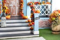 Halloween design home with yellow fall leaves. House entrance staircase decorated for autumn holidays, fall flowers and pumpkins. Royalty Free Stock Photo