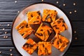 Halloween dessert cream Cheese Brownies consisting of a dark chocolate cake topped with a layer of orange cheesecake close-up. Ho Royalty Free Stock Photo