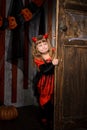 halloween devil girl looking out of old door Royalty Free Stock Photo