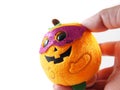 Halloween doll with fancy pink mask, orange pumpkin on hand
