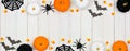 Halloween double border banner with black, orange and white decor and candy over white wood Royalty Free Stock Photo