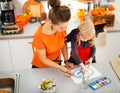 Halloween dressed girl with mother drawing Jack-O-Lantern Royalty Free Stock Photo