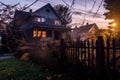 Halloween-dressed home facade with cobwebs, spiders, and paper bats, in warm sunset glow. Royalty Free Stock Photo