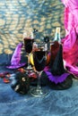 Halloween drinks, wine, pumpkins, mystical decorations, dry roses and shadows on a black background