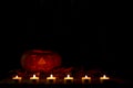 Halloween face silhouette made of pumpkins and candles. Royalty Free Stock Photo