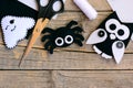 Halloween felt ornaments. Felt ghost, spider, owl ornaments on a vintage wooden table. Sewing craft tools and materials Royalty Free Stock Photo