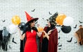 Halloween Festive with Asian influencer two girl wear witch dress and vampire costume playing pumpkin bucket while holding party Royalty Free Stock Photo