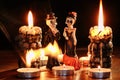 Halloween: figures of two skeletons of the man and the woman against the background of the burning candles in the form