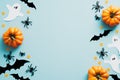 Halloween flat lay composition with orange pumpkins, ghosts, spiders, bats on blue background. Happy Halloween holiday greeting