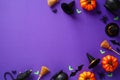 Halloween flat lay composition. Top view pumpkins, witch`s pots, hats, brooms, spiders, bats on purple background