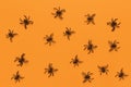 Halloween flat lay. Pattern from black spiders on orange background. Minimal style. Horizontal. Trick-or-treat concept