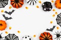 Halloween frame flat lay of pumpkins, candy and decor, over a white background