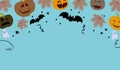 Halloween frame with party decorations of pumpkins, bats, ghosts, spiders on blue background from above. Royalty Free Stock Photo