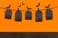 Halloween fun orange background with black blank sale labels and dark wooden board, mock up.