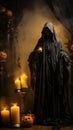 a halloween ghost in a black robe with candles and pumpkins Royalty Free Stock Photo
