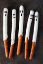 Halloween ghost, candy dipped pretzel rods on black stone