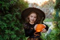 Halloween. The girl is dressed in dark dress and hat. Royalty Free Stock Photo