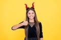Halloween girl in red imp horns playing trick o treat showing thumb up, happy halloween Royalty Free Stock Photo