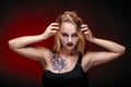 Halloween girl vampire with red eyes red lips and red background Royalty Free Stock Photo