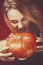 Halloween girl vampire with red eyes red lips and dark red background. Scary woman trick or treat time, halloween concept. Female Royalty Free Stock Photo