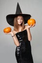 Halloween girl witch hat holding pumpkins in hand Royalty Free Stock Photo